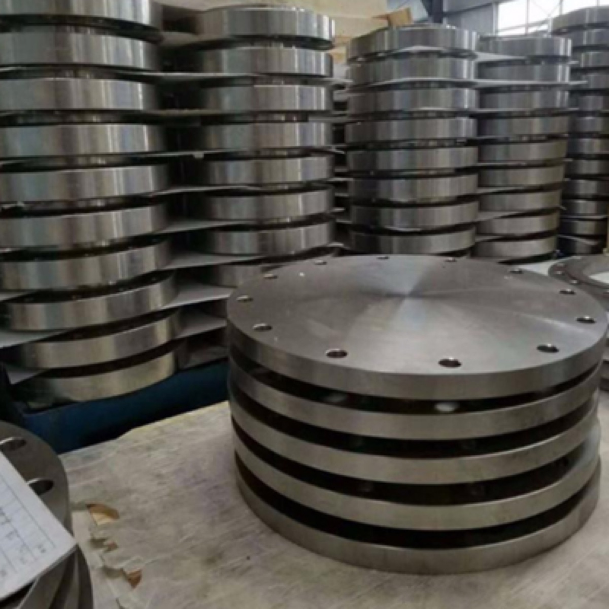 Stacks of machined blind flanges with controlled 125 AARH gasket face finish at the works