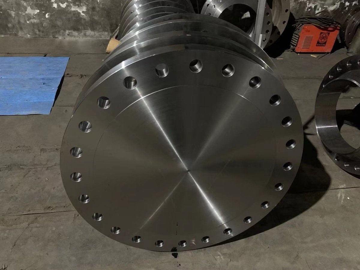 Large forged carbon steel blind flanges with raised face machined and stacked at the flange works
