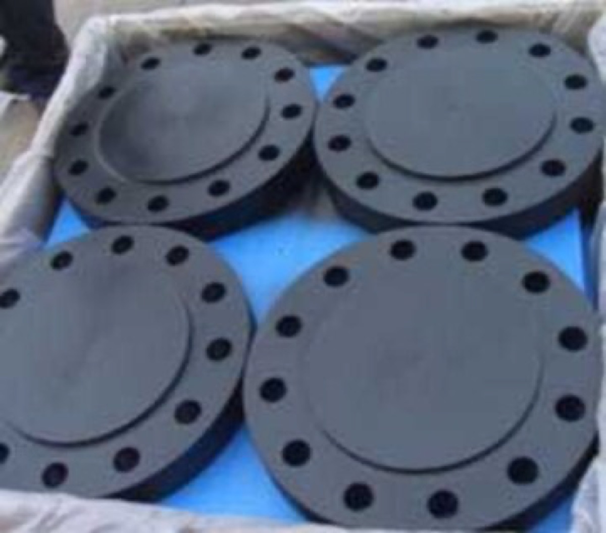 Black coated alloy steel raised face blind flanges packed in lined crate on separators