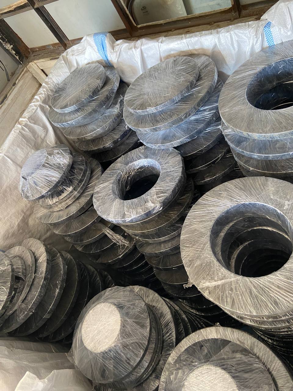 ASTM A182 alloy steel weld neck flanges individually plastic-wrapped and bulk-loaded for export — Cr-Mo F22 F91 Grade 91 WNRF flanges exporter Tesco Steel India