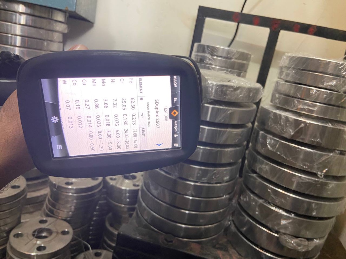 Handheld PMI spectrometer confirming super duplex 2507 chemistry on F53 flange stock — good match on Cr, Ni, Mo