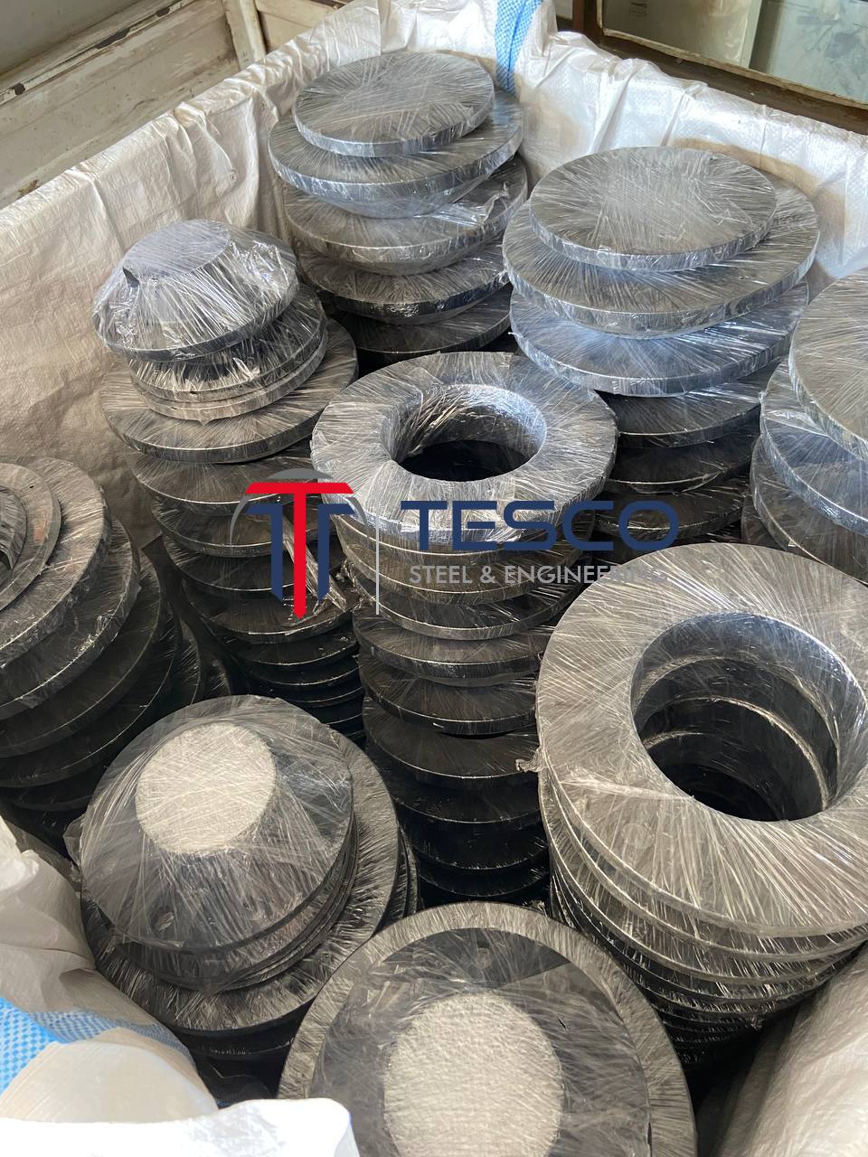ASTM A350 LF2 LTCS weld neck flanges individually plastic-wrapped and stacked in wooden export crate — low temperature carbon steel WNRF flanges exporter Mumbai India