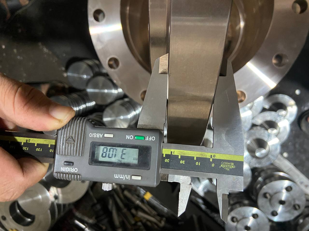 Dimensional inspection of Cupro Nickel flange face width using digital vernier caliper during in-process quality control