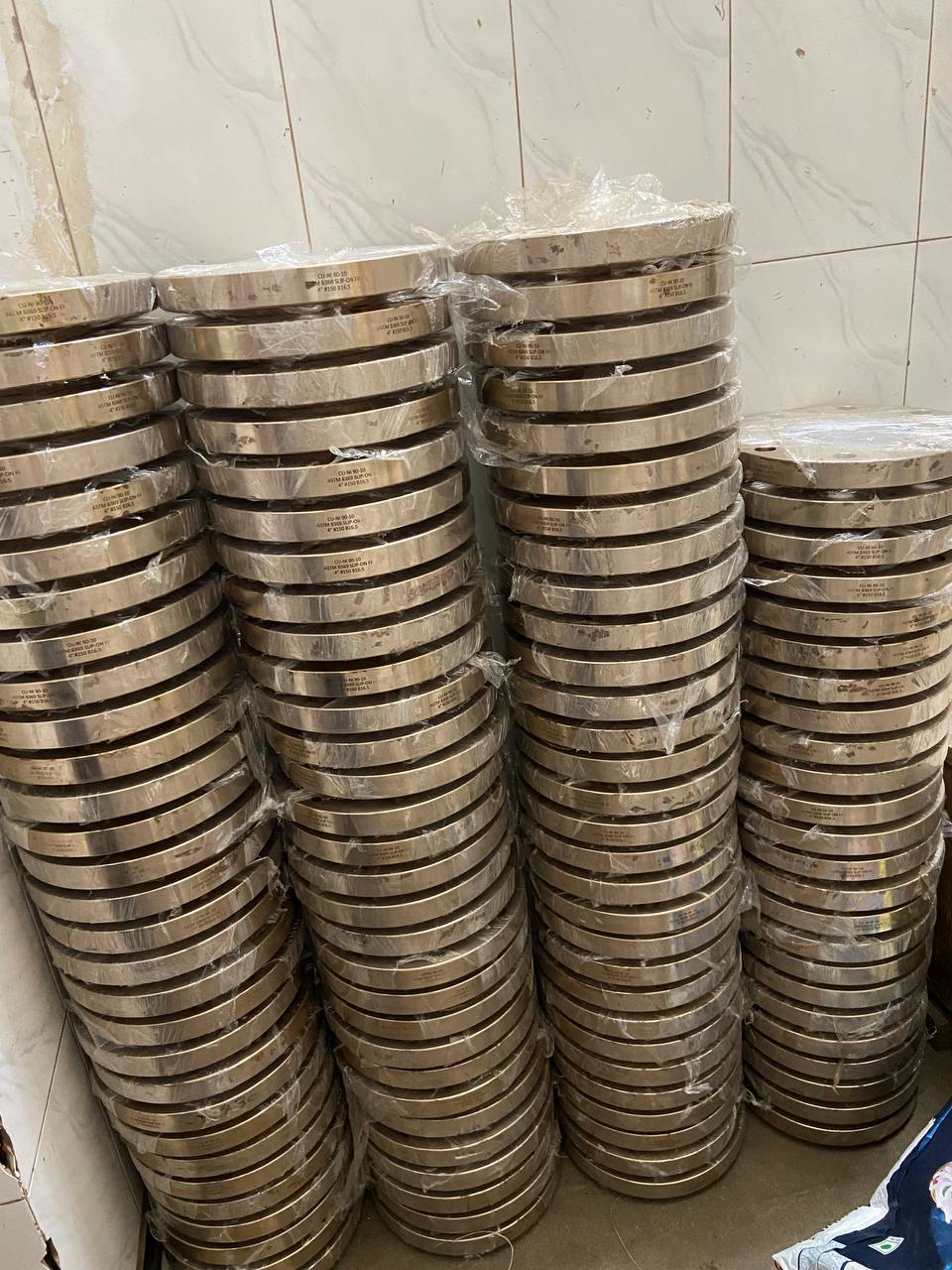 Cupro Nickel 90/10 flanges individually wrapped in moisture-barrier plastic film stacked in bulk ready for export dispatch