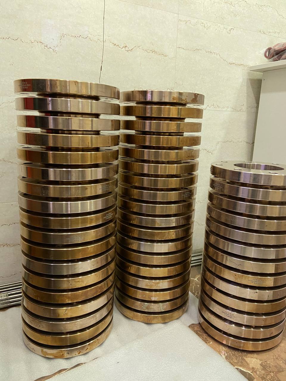 Bulk stock of Cupro Nickel 90/10 slip-on flanges stacked in three columns awaiting export dispatch