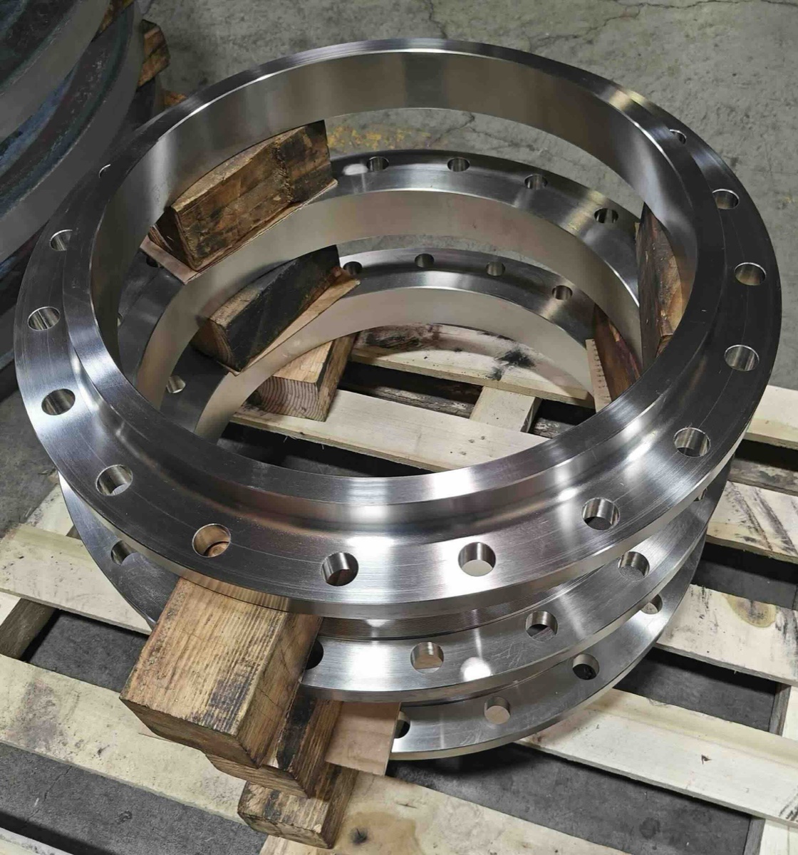 Large machined slip on flanges stacked on wooden pallet ready for despatch at flange works