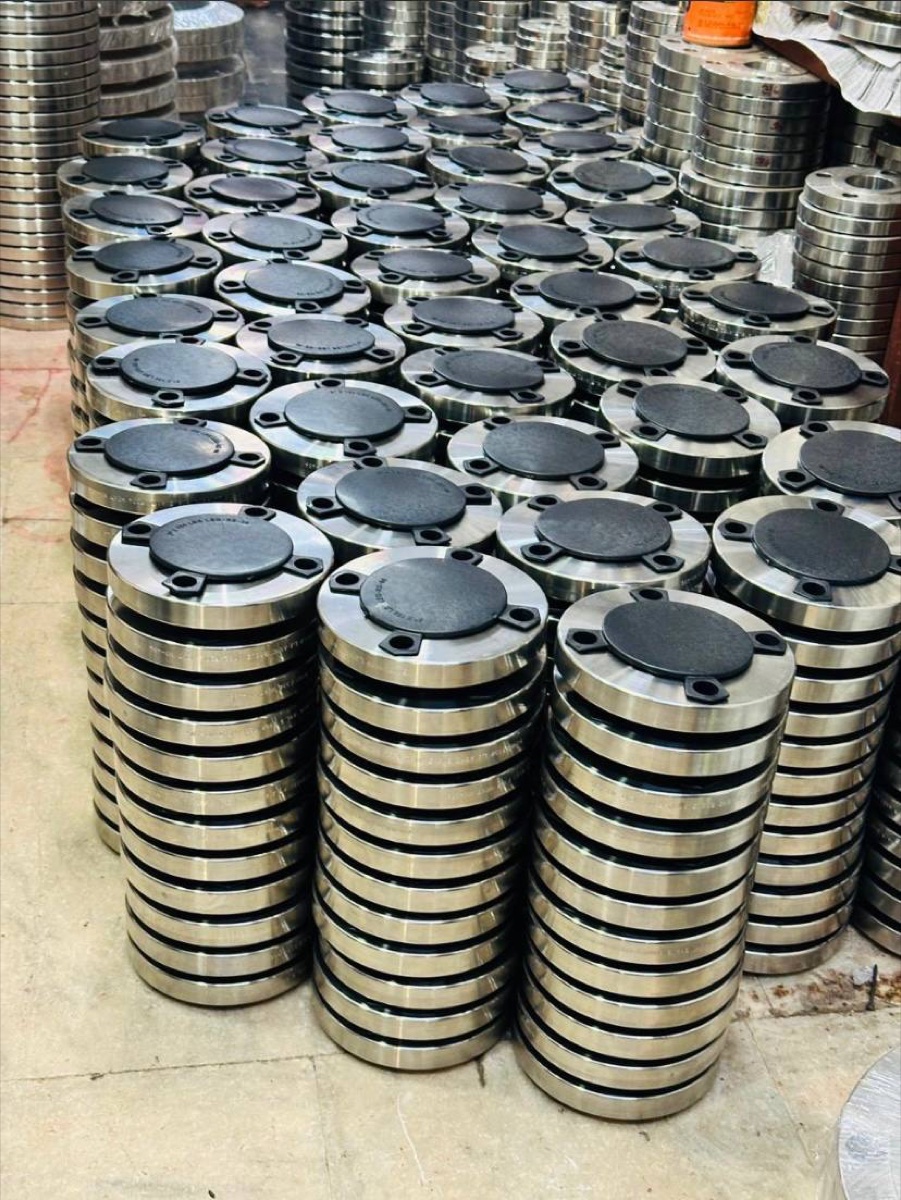 Stainless steel flanges stacked with black face protectors at Tesco Steel & Engineering warehouse